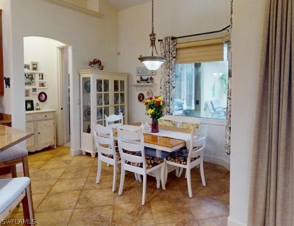 dining room with a high ceiling and light tile floors