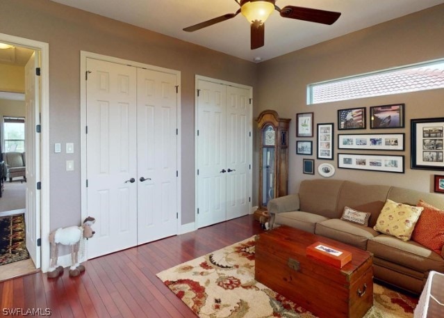 living room featuring dark hardwood / wood-style flooring and ceiling fan