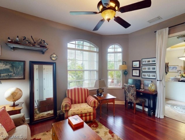 living room with ceiling fan and dark wood-type flooring