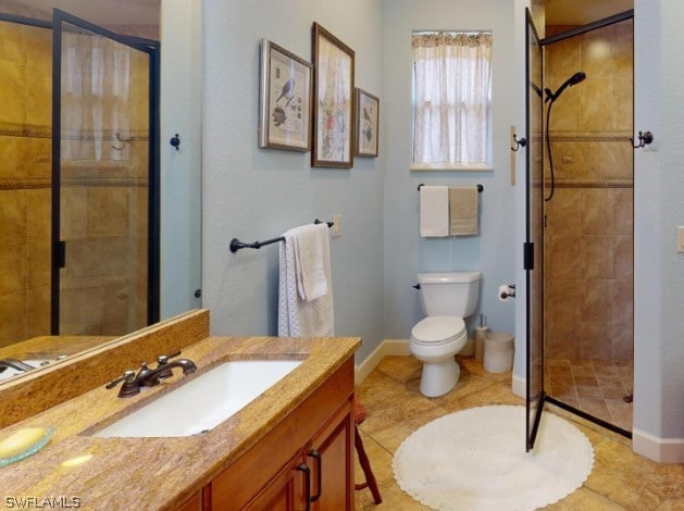 bathroom featuring a shower with door, tile flooring, toilet, and vanity