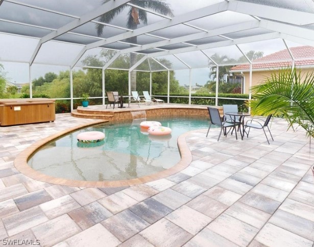 view of swimming pool featuring a patio area, a lanai, and a hot tub