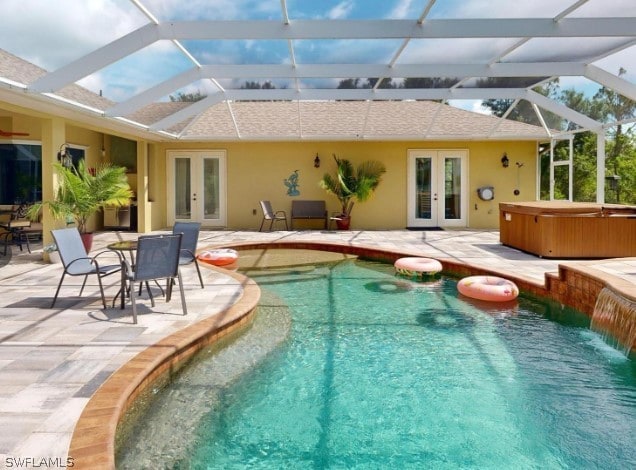 view of swimming pool featuring a patio, a hot tub, french doors, and glass enclosure