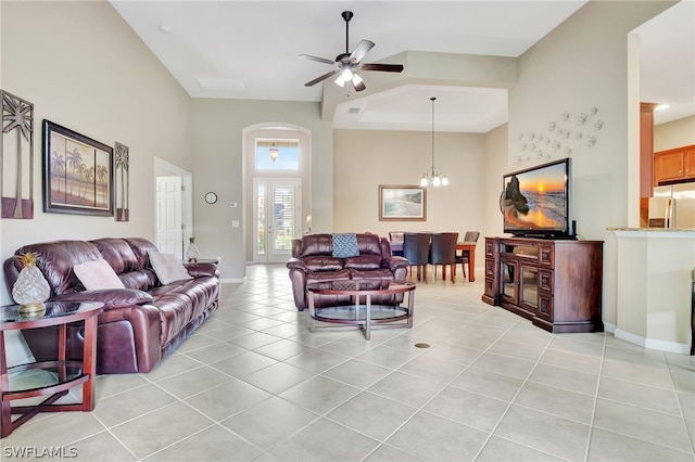 tiled living room with french doors and ceiling fan with notable chandelier