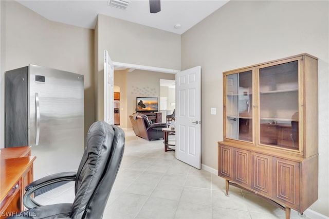 tiled office with ceiling fan and a high ceiling