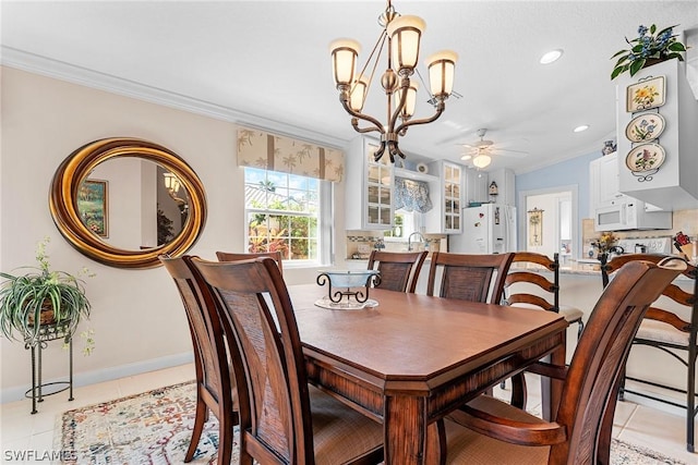 tiled dining space with ceiling fan with notable chandelier and ornamental molding