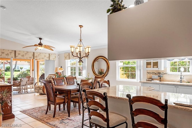 dining area with ceiling fan with notable chandelier, sink, light tile patterned floors, and ornamental molding