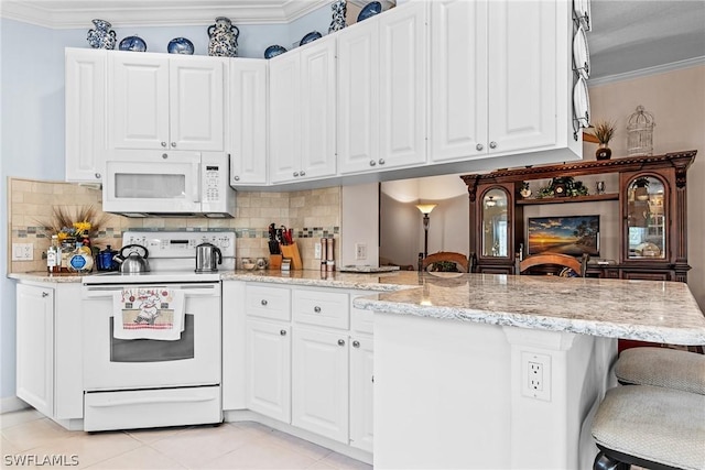 kitchen with white cabinetry, white appliances, kitchen peninsula, and decorative backsplash