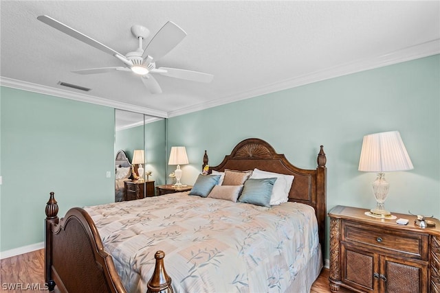 bedroom with ceiling fan, hardwood / wood-style flooring, a closet, and ornamental molding