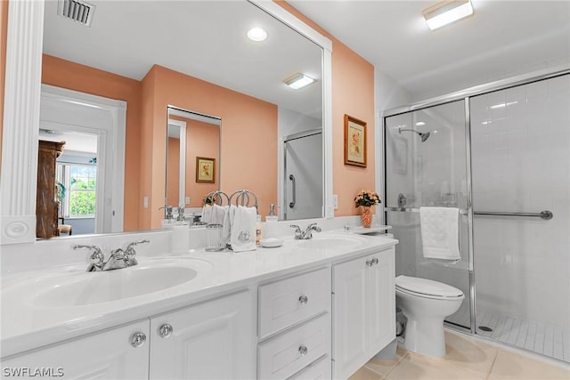 bathroom with toilet, tile patterned floors, vanity, and an enclosed shower