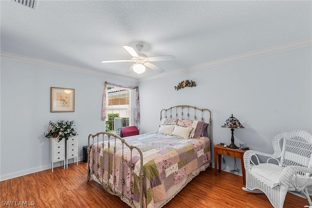 bedroom with ceiling fan, wood-type flooring, crown molding, and a textured ceiling