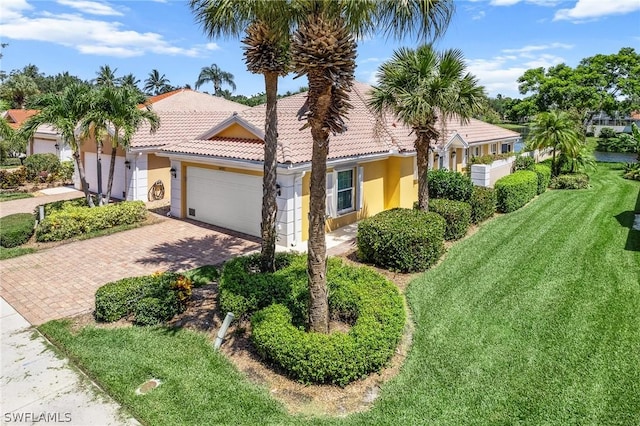 mediterranean / spanish-style home featuring a garage and a front lawn