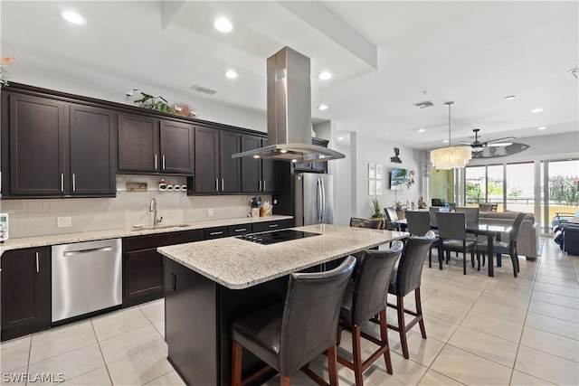 kitchen with island exhaust hood, appliances with stainless steel finishes, sink, a center island, and hanging light fixtures