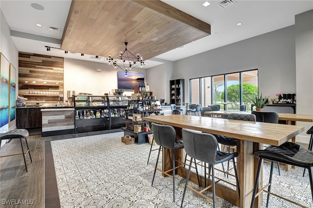 interior space with wood counters, wood ceiling, wooden walls, light hardwood / wood-style flooring, and a notable chandelier