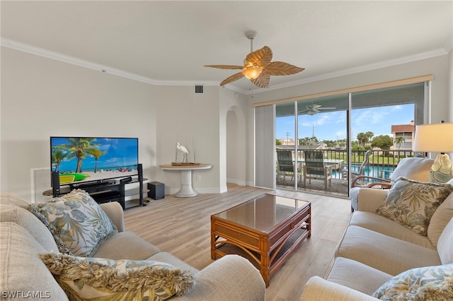 living room with light hardwood / wood-style flooring, ceiling fan, and crown molding