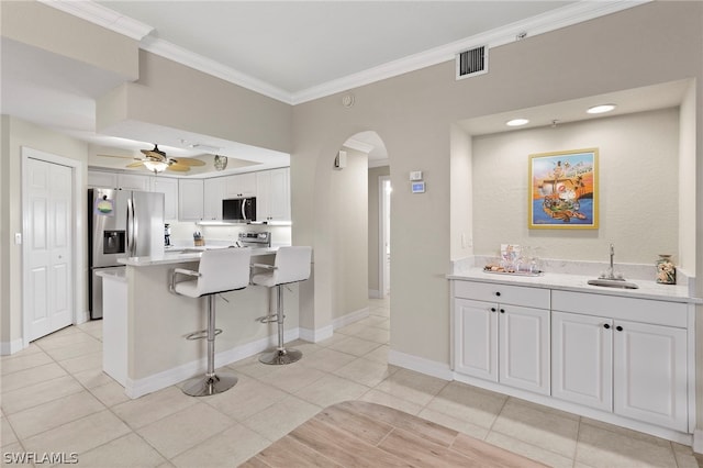 kitchen with stainless steel fridge with ice dispenser, kitchen peninsula, a breakfast bar area, white cabinets, and ornamental molding