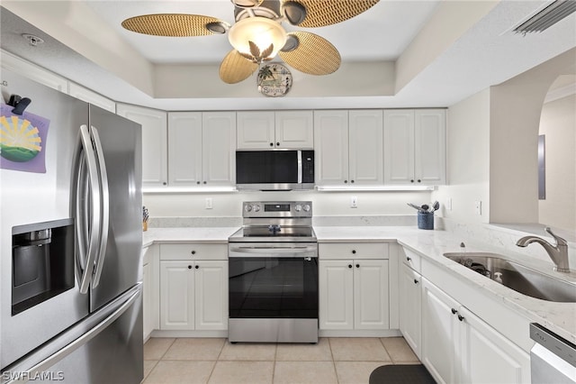 kitchen featuring white cabinets, sink, ceiling fan, light tile patterned floors, and stainless steel appliances