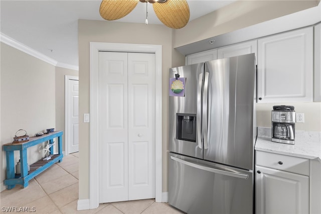 kitchen featuring ceiling fan, stainless steel fridge, white cabinetry, and light tile patterned floors