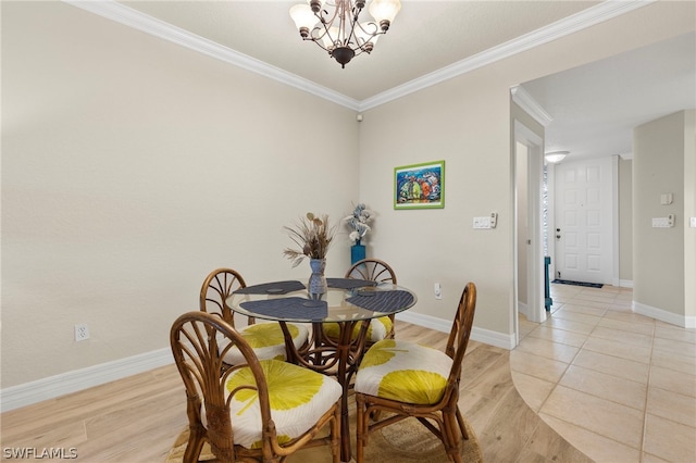 dining area with light hardwood / wood-style floors, an inviting chandelier, and ornamental molding