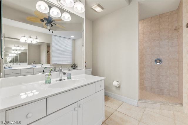 bathroom featuring tile patterned flooring, vanity, tiled shower, and ceiling fan