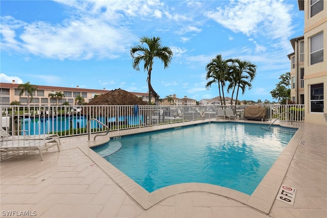 view of pool with a patio area and a water view