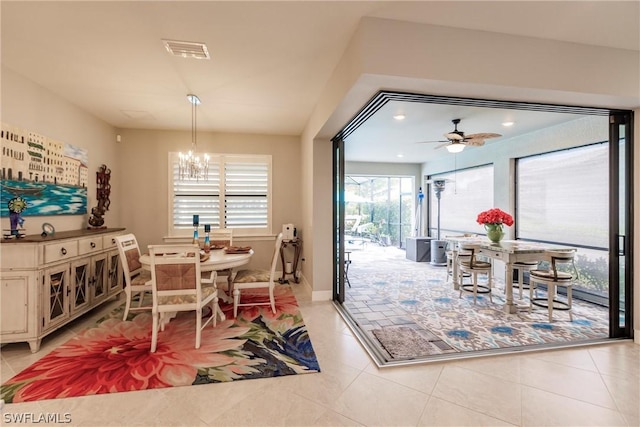 dining area featuring light tile patterned floors and ceiling fan with notable chandelier