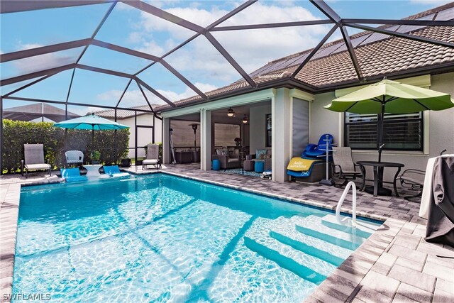 view of pool featuring a lanai, ceiling fan, and a patio