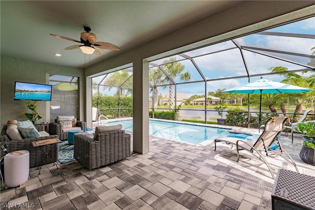 view of swimming pool with a lanai, ceiling fan, a patio area, outdoor lounge area, and a water view