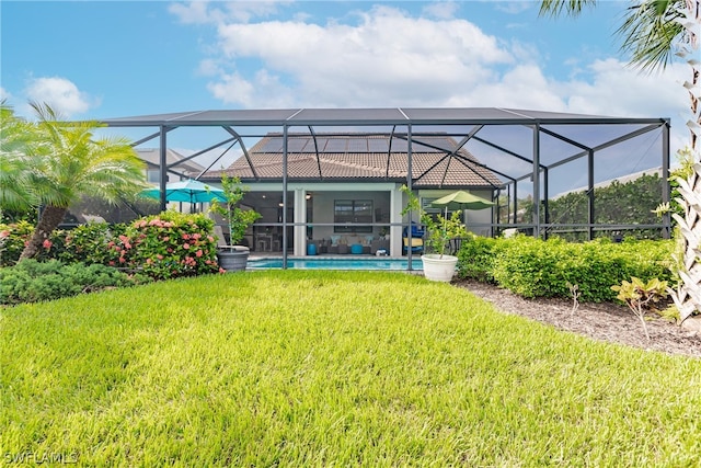 back of house featuring a lawn and glass enclosure