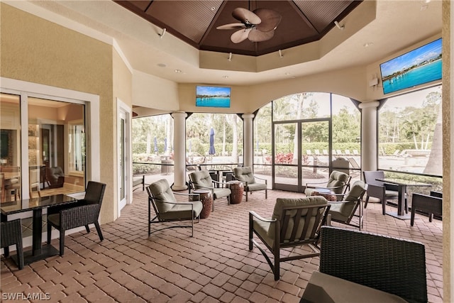 sunroom / solarium featuring ornate columns, ceiling fan, and wooden ceiling