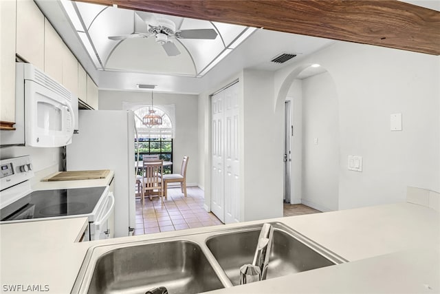 kitchen featuring white cabinetry, ceiling fan, sink, hanging light fixtures, and white appliances