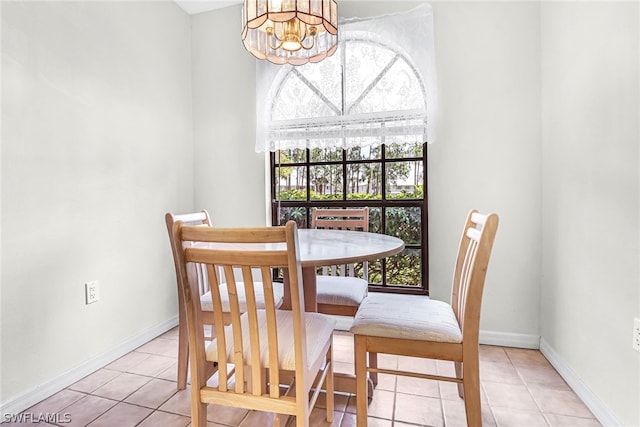 tiled dining area featuring a notable chandelier