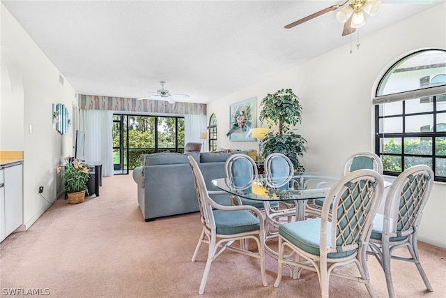 carpeted dining room with ceiling fan