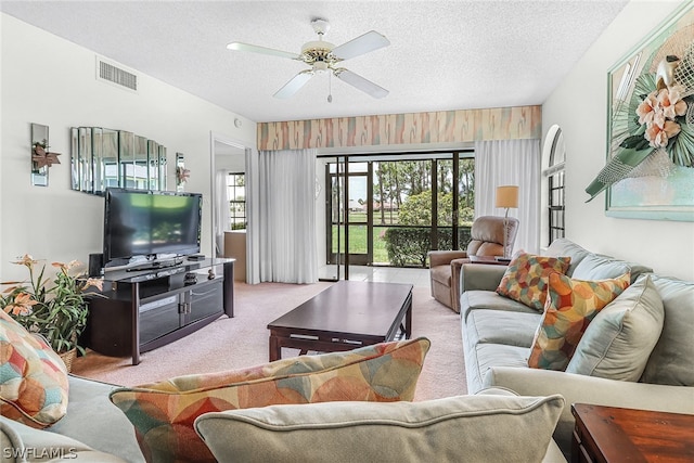 living room with light carpet, a textured ceiling, and ceiling fan