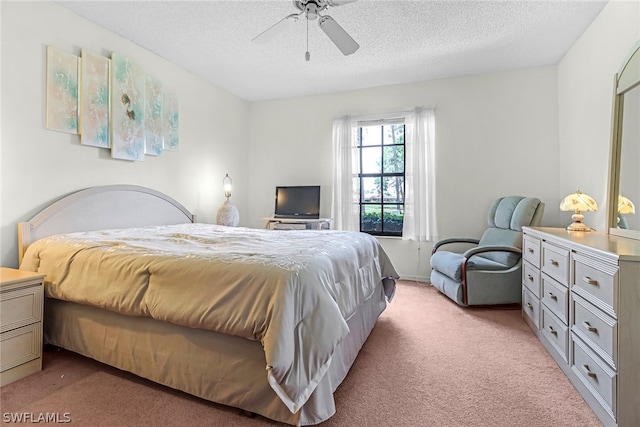 bedroom featuring a textured ceiling, ceiling fan, and light carpet