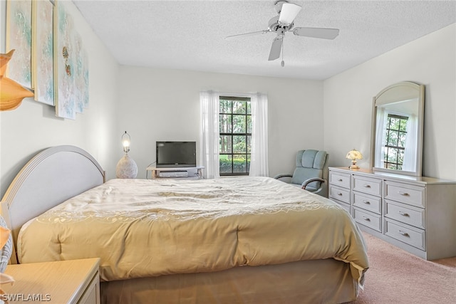 bedroom with carpet, ceiling fan, and a textured ceiling