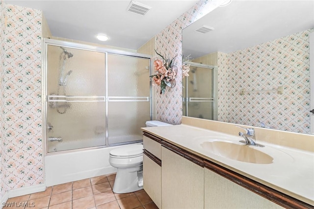 full bathroom with shower / bath combination with glass door, tile patterned flooring, vanity, and toilet