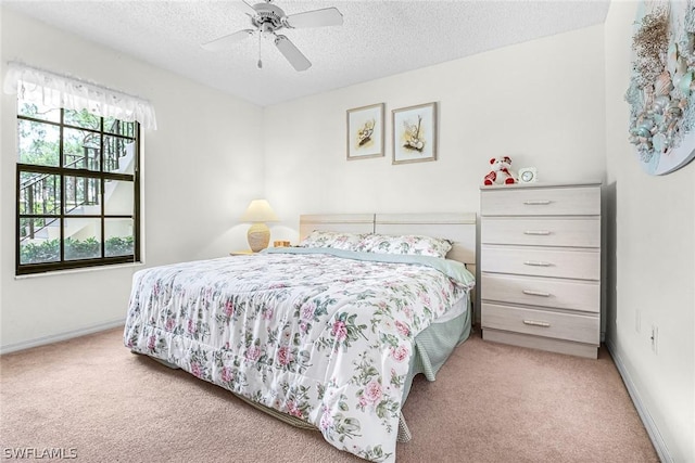 carpeted bedroom with ceiling fan and a textured ceiling