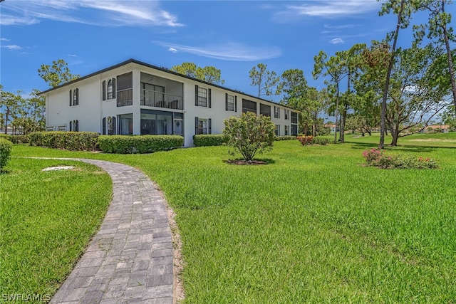 rear view of property with stucco siding and a lawn