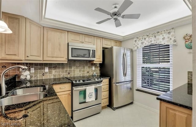 kitchen featuring dark stone counters, light tile flooring, tasteful backsplash, appliances with stainless steel finishes, and sink