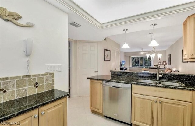 kitchen featuring dark stone counters, stainless steel dishwasher, pendant lighting, light tile floors, and sink