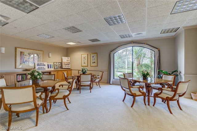 dining room with light colored carpet and crown molding