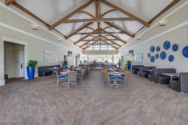 interior space with high vaulted ceiling, beamed ceiling, and hardwood / wood-style flooring