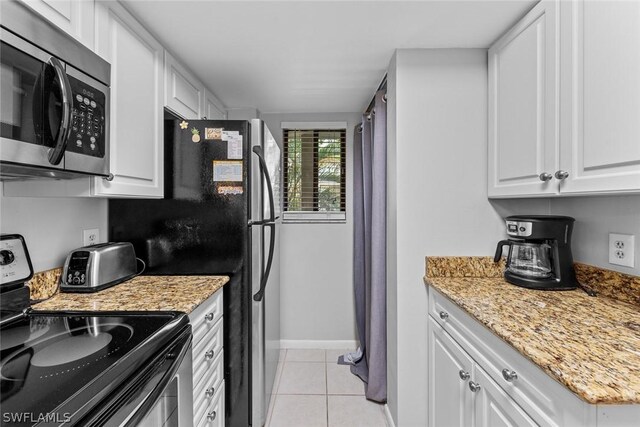 kitchen with light stone counters, light tile floors, white cabinetry, and appliances with stainless steel finishes