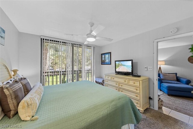 bedroom featuring access to exterior, light tile patterned floors, a ceiling fan, and light colored carpet