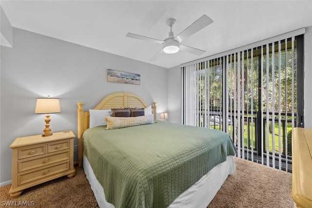 bedroom with access to exterior, dark colored carpet, and a ceiling fan