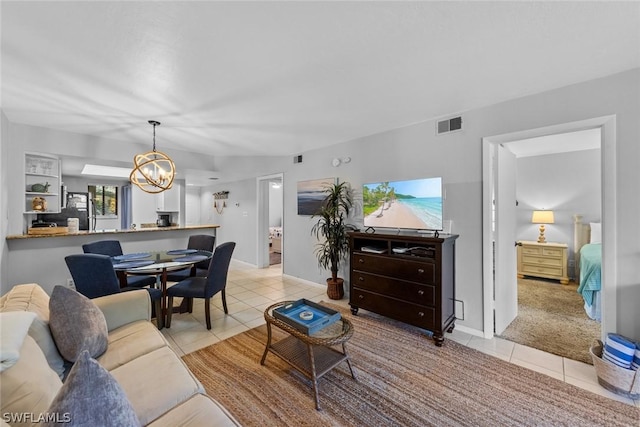 living area with light tile patterned floors, baseboards, visible vents, and an inviting chandelier