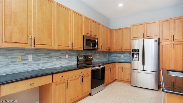 kitchen with appliances with stainless steel finishes, dark stone countertops, light brown cabinets, and decorative backsplash