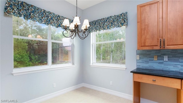 unfurnished dining area featuring a notable chandelier, baseboards, and light tile patterned floors