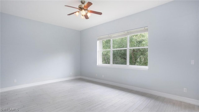 empty room with light wood-style floors, ceiling fan, and baseboards