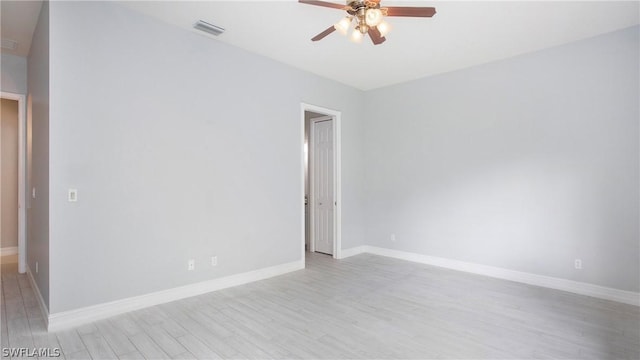 unfurnished room with light wood-style floors, ceiling fan, visible vents, and baseboards